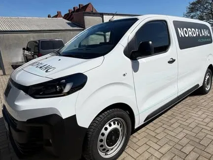 Weißer Transporter mit dezenter Seitenbeschriftung